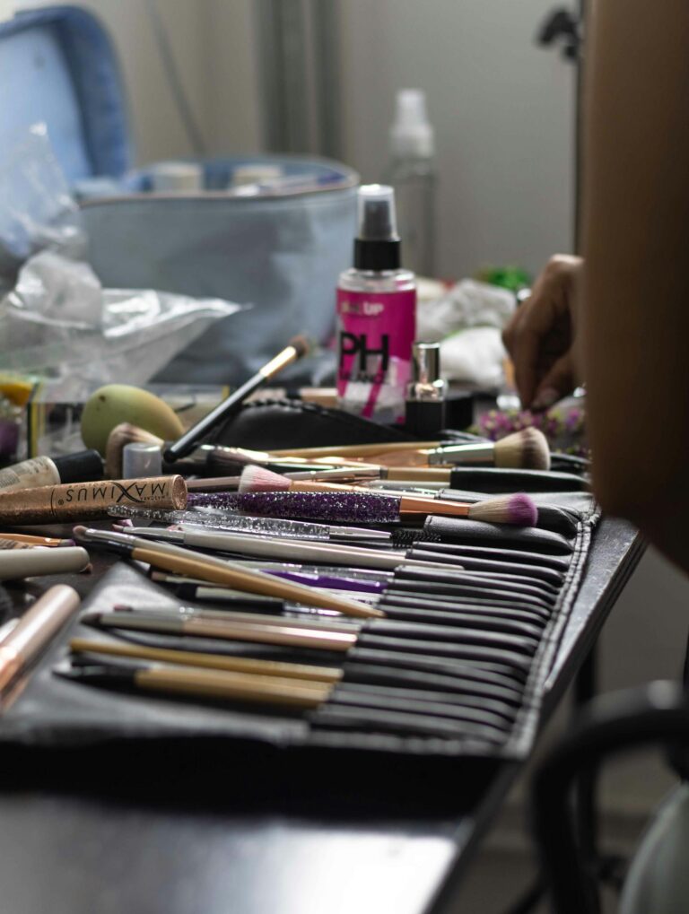 Close-up of a professional makeup kit with brushes and accessories on a table, ideal for beauty enthusiasts.